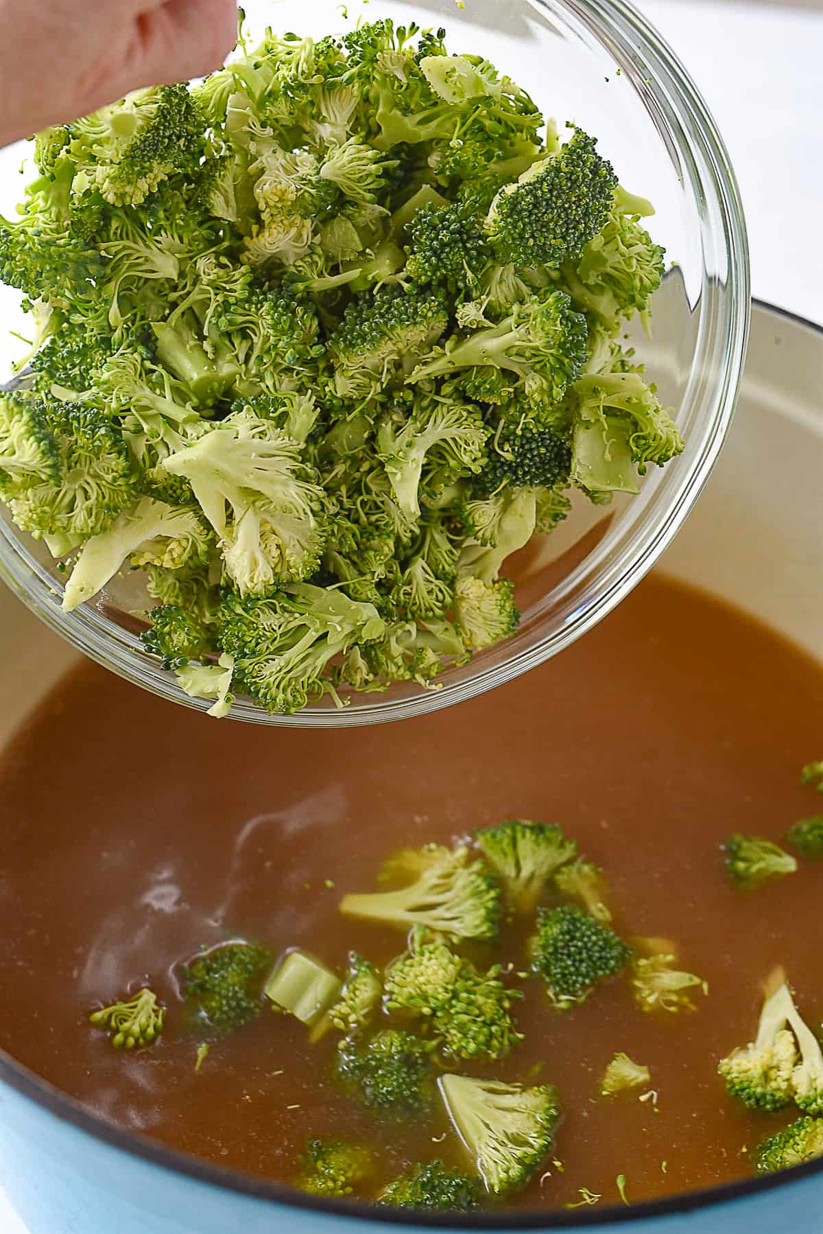 adding broccoli into broth