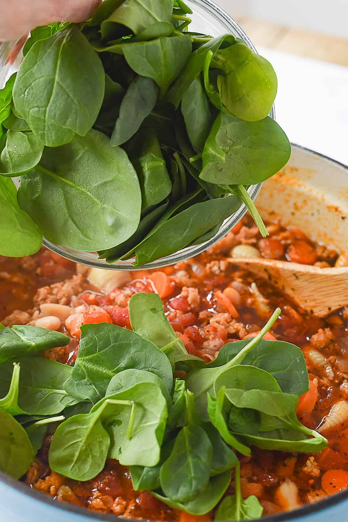 adding spinach into soup