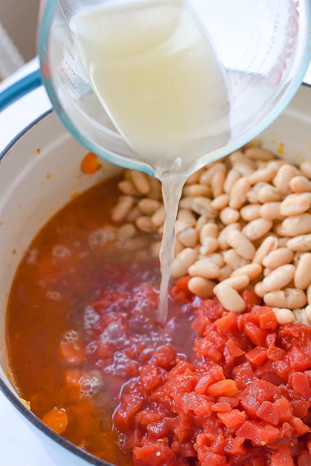 adding broth into soup