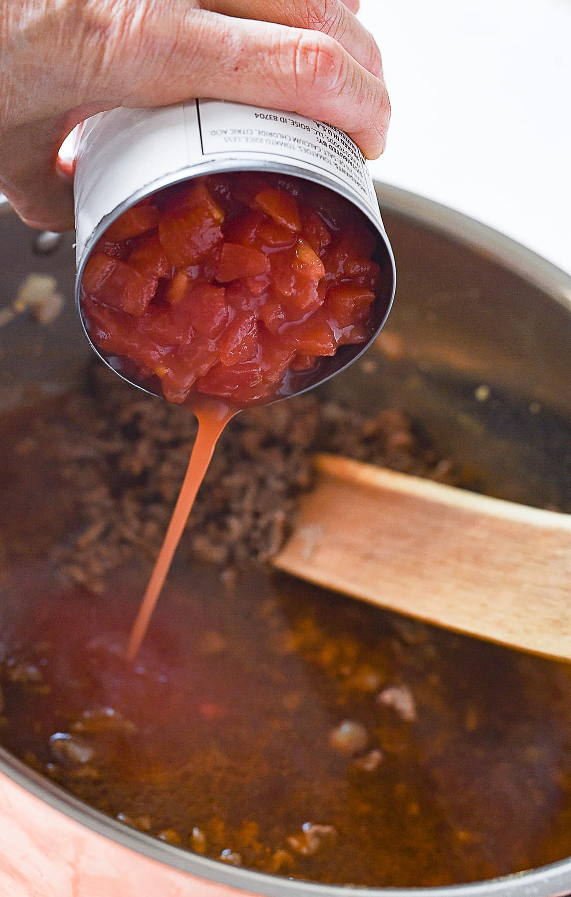 adding tomatoes into chili