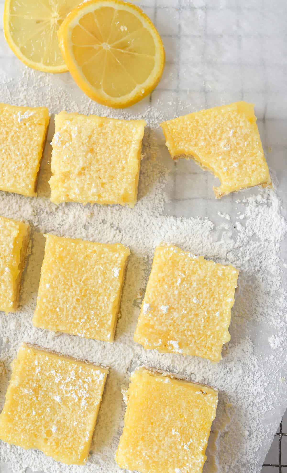 overhead shot of lemon cheesecake bars with a bite out of one bar