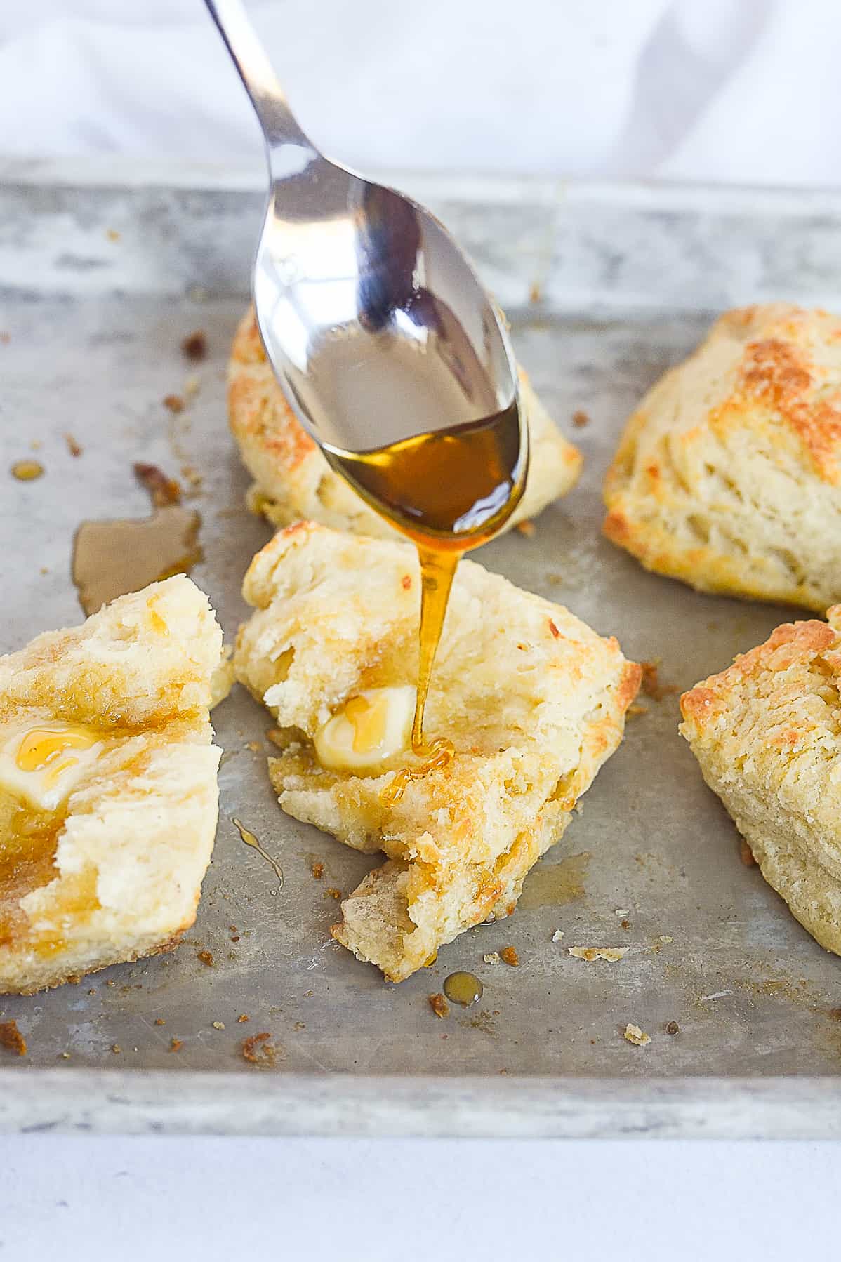 pouring honey on a biscuit