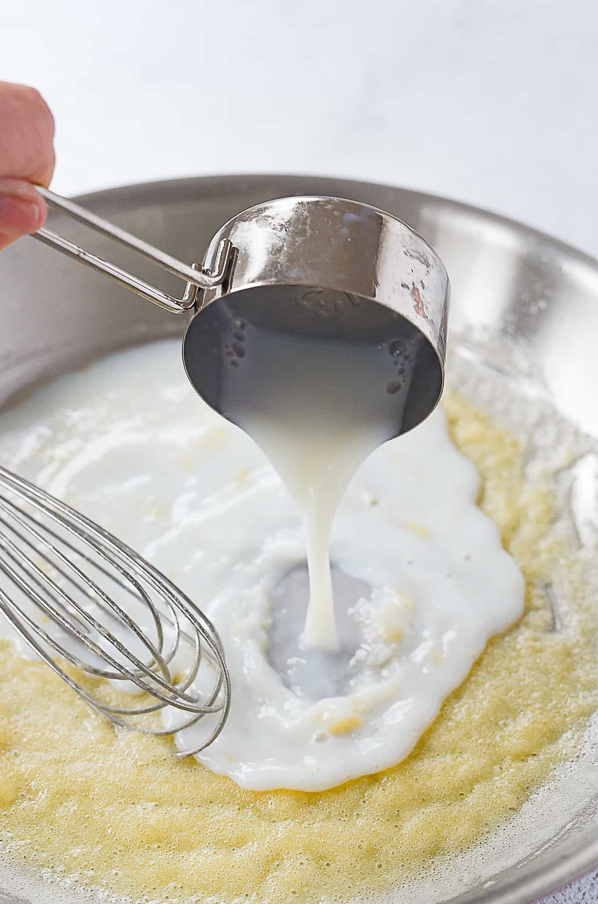 adding milk to sauce pan