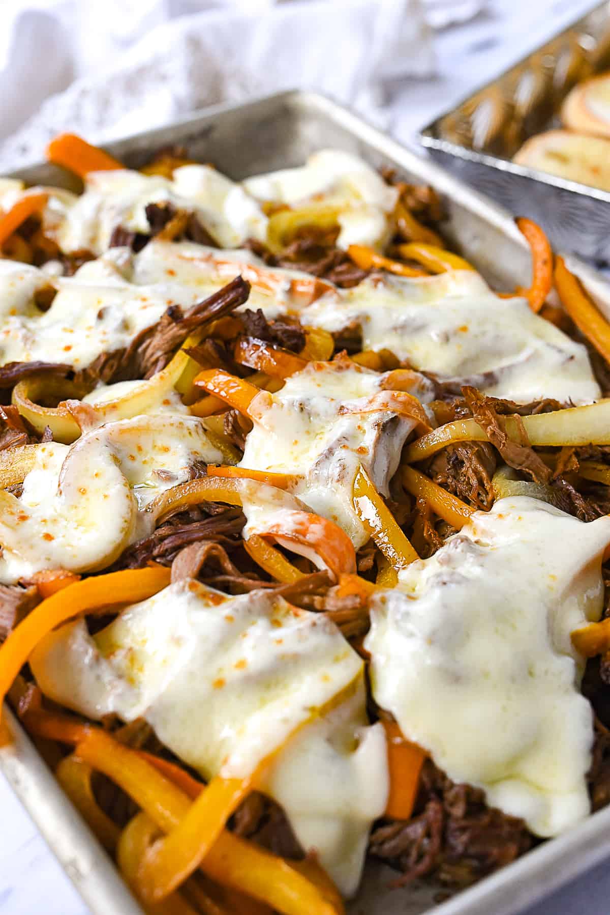 melted cheese on top of philly cheesesteak