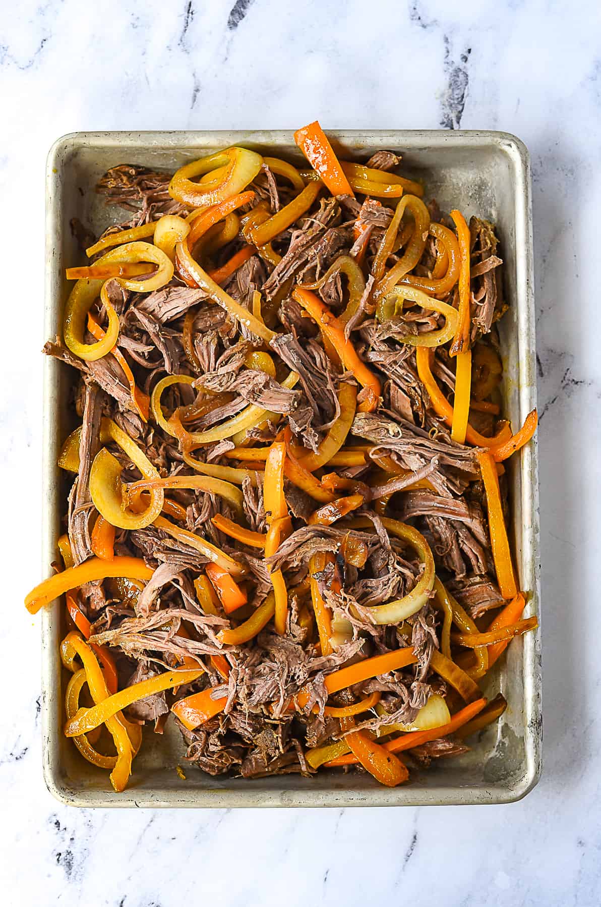meat and peppers on a baking sheet