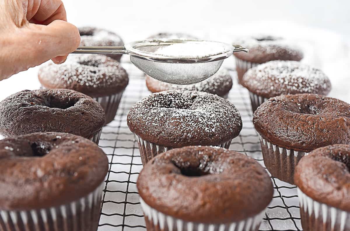 adding powdered sugar to chocolate cupcakes
