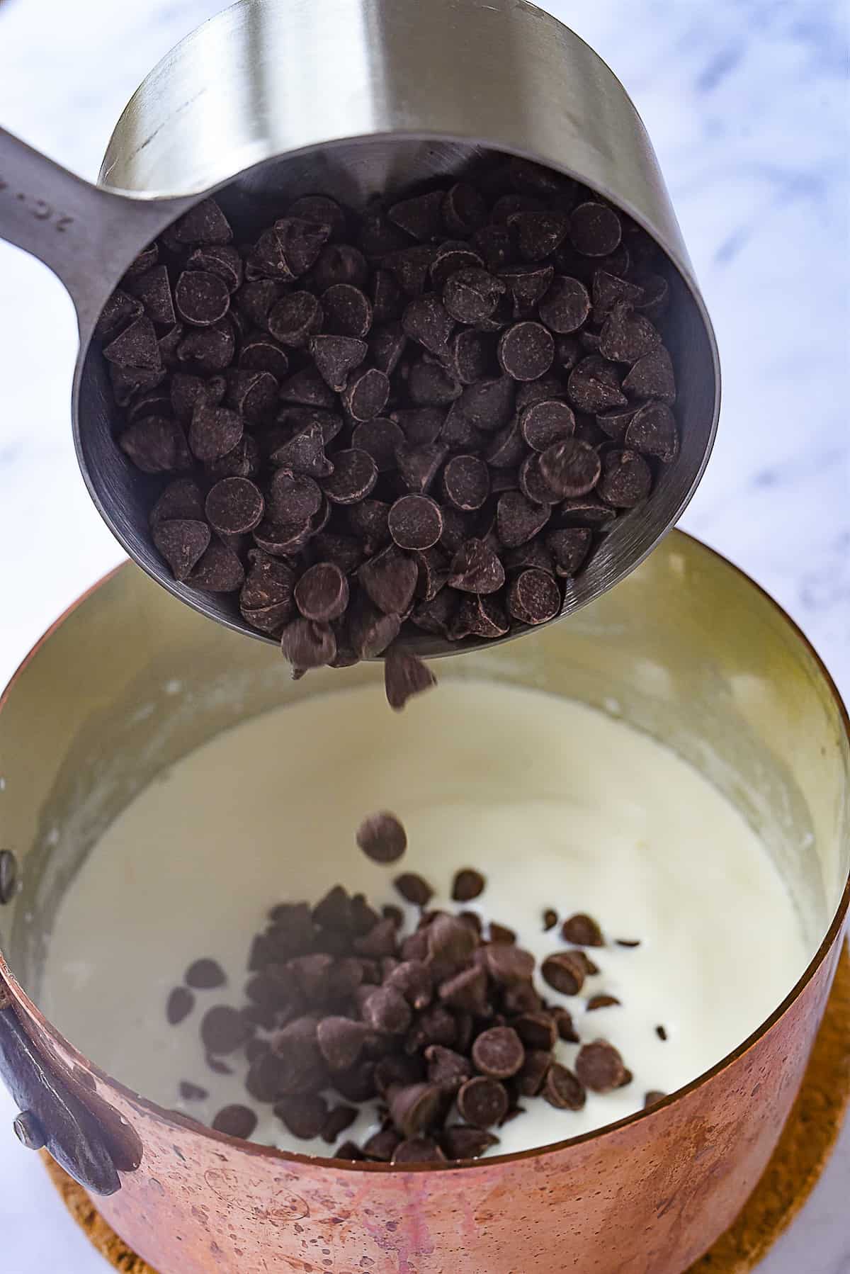 adding chocolate chips to ganache.