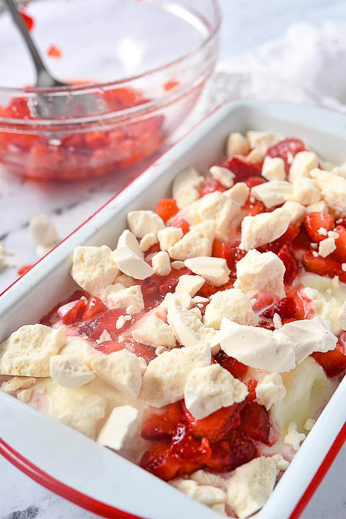 meringues and strawberries on top of ice cream