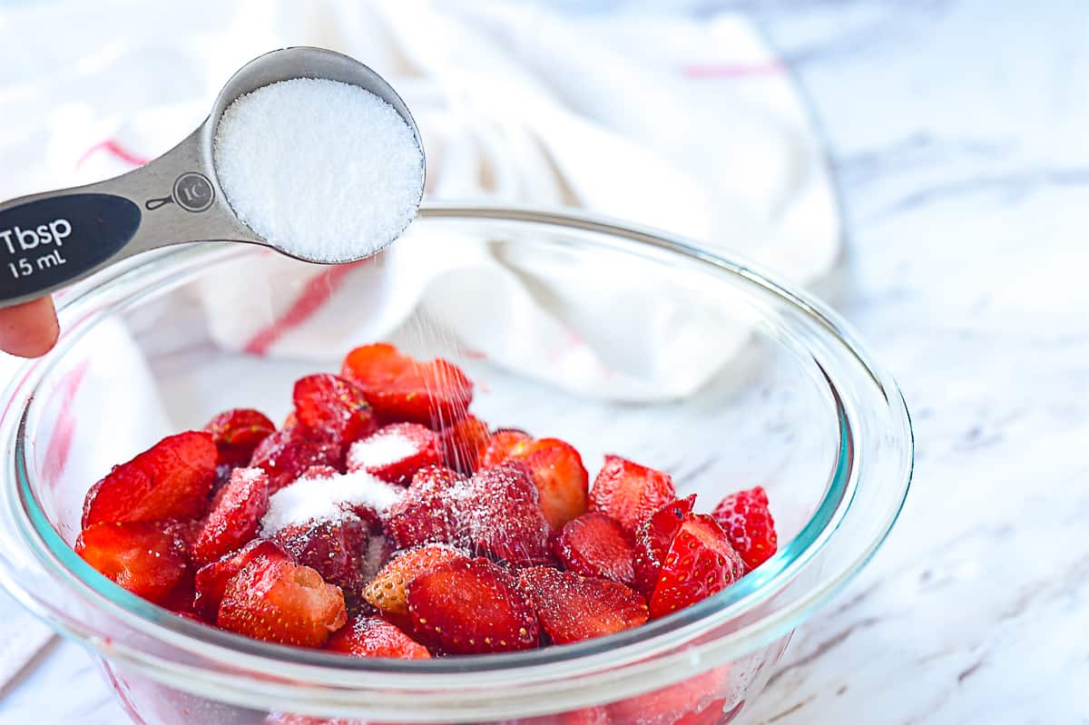 sprinkling sugar on strawberries