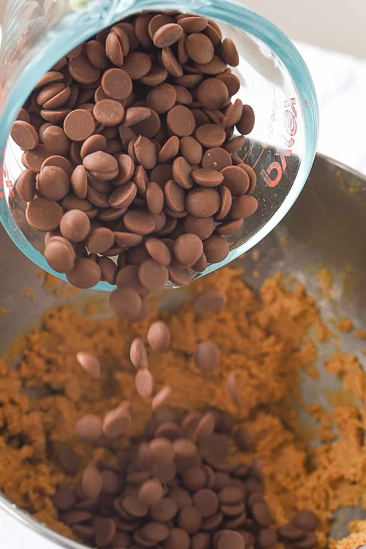 adding chocolate chips to cookie batter