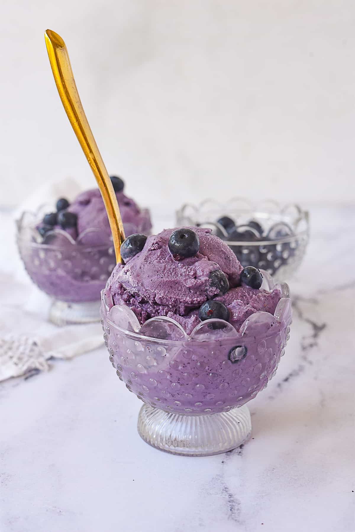 bowl of blueberry ice cream with a spoon in it