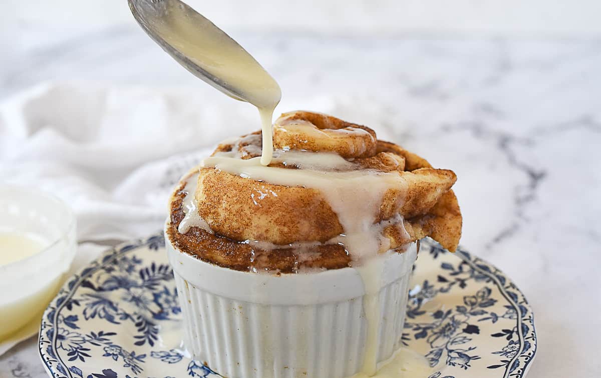 drizzling glaze on cinnamon roll