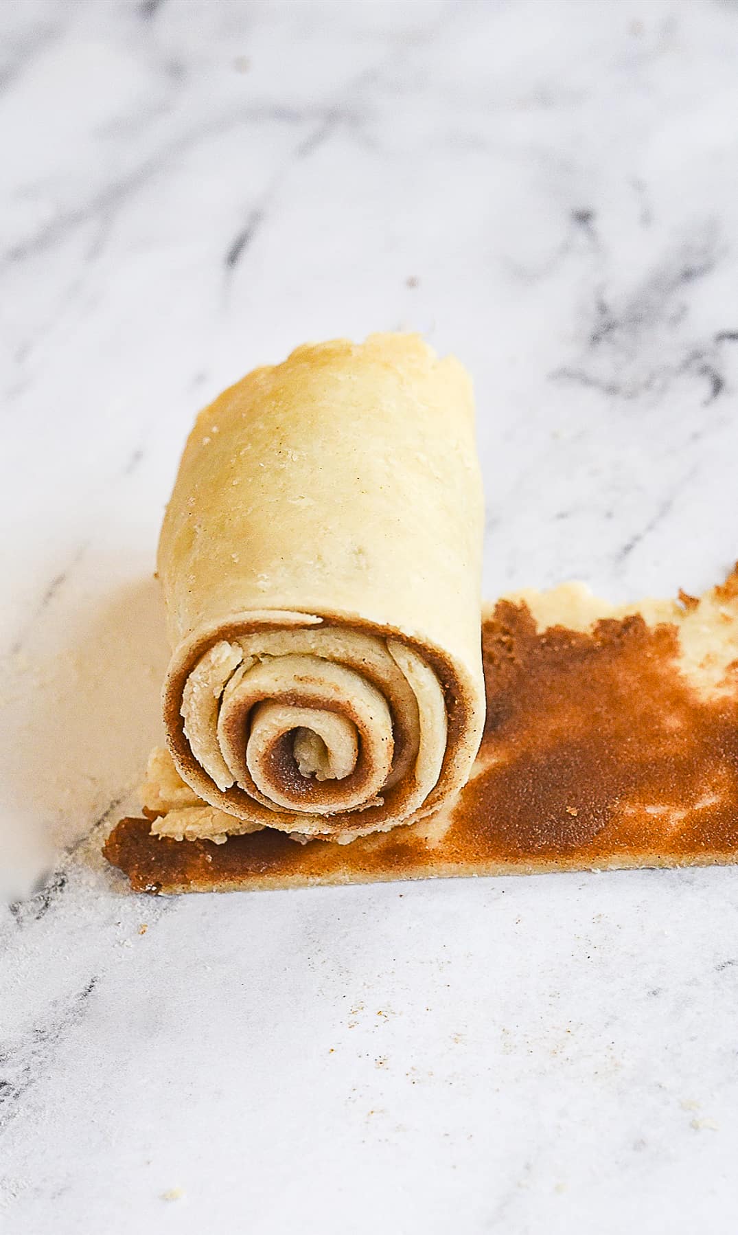 rolling up a cinnamon roll