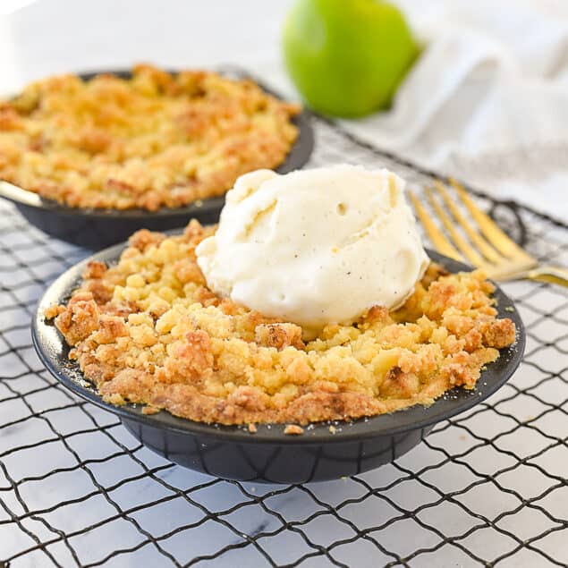 two mini apple pies on a cooling rack