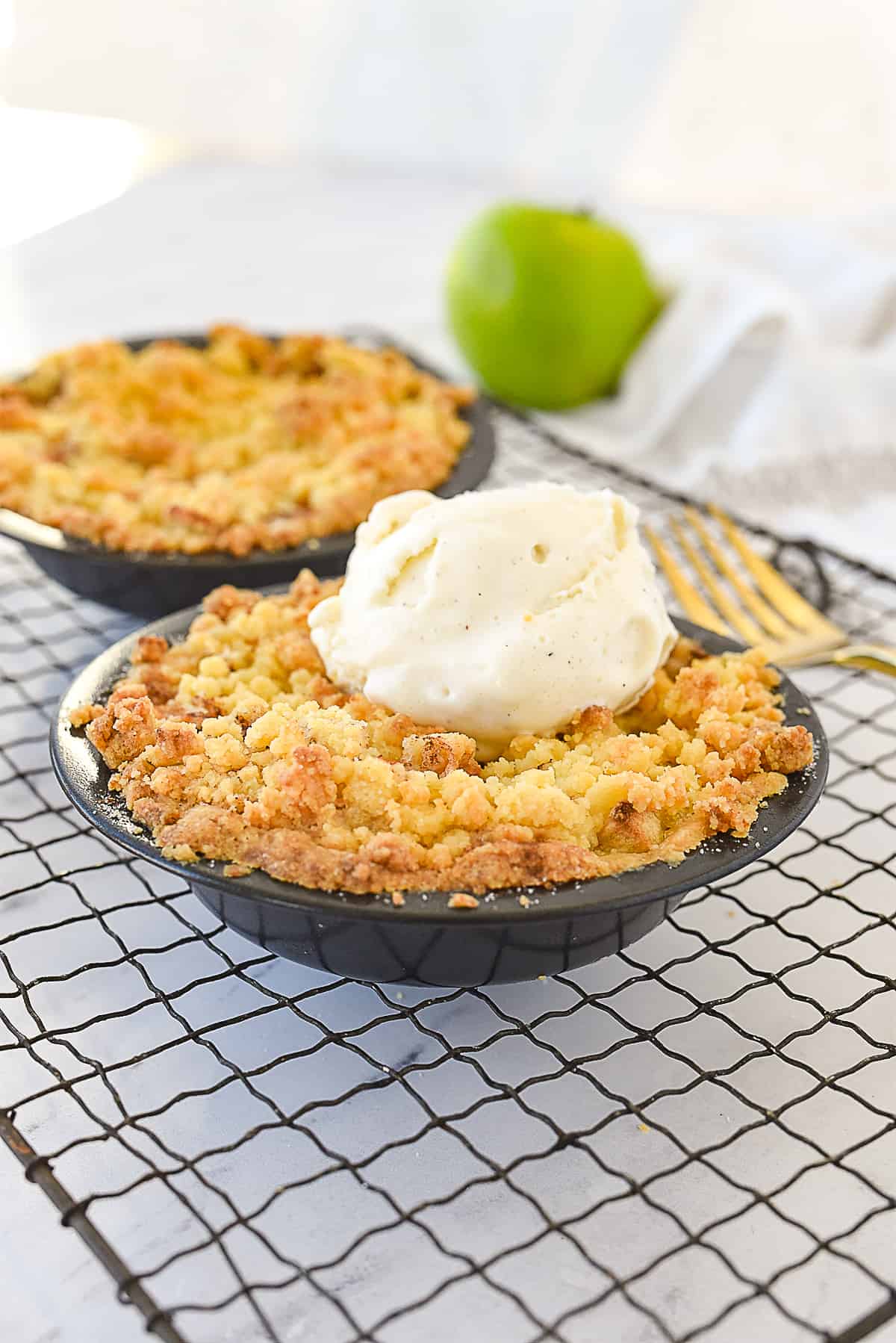 two mini apple pies on a cooling rack