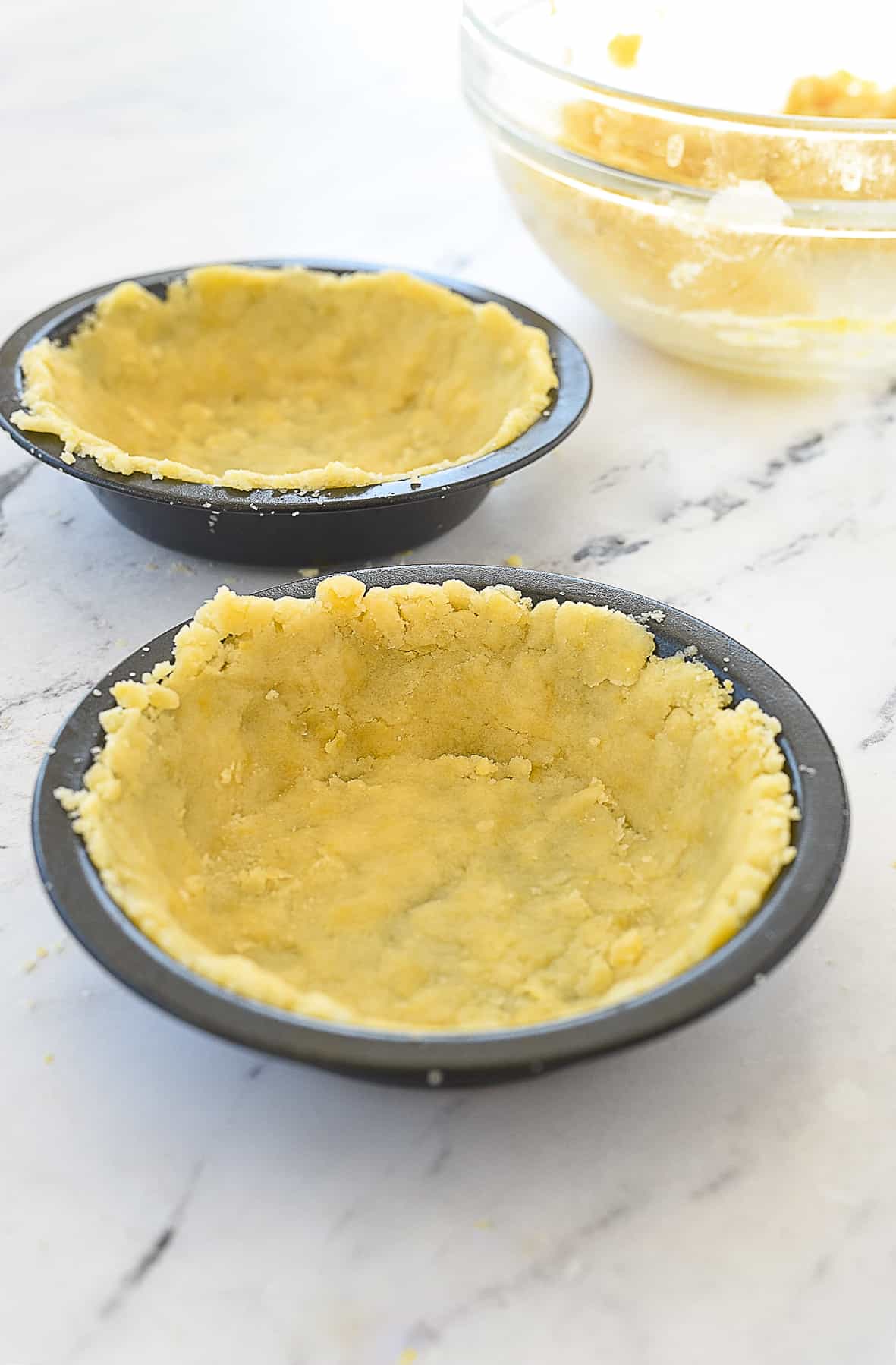 dough pressed into pie tins