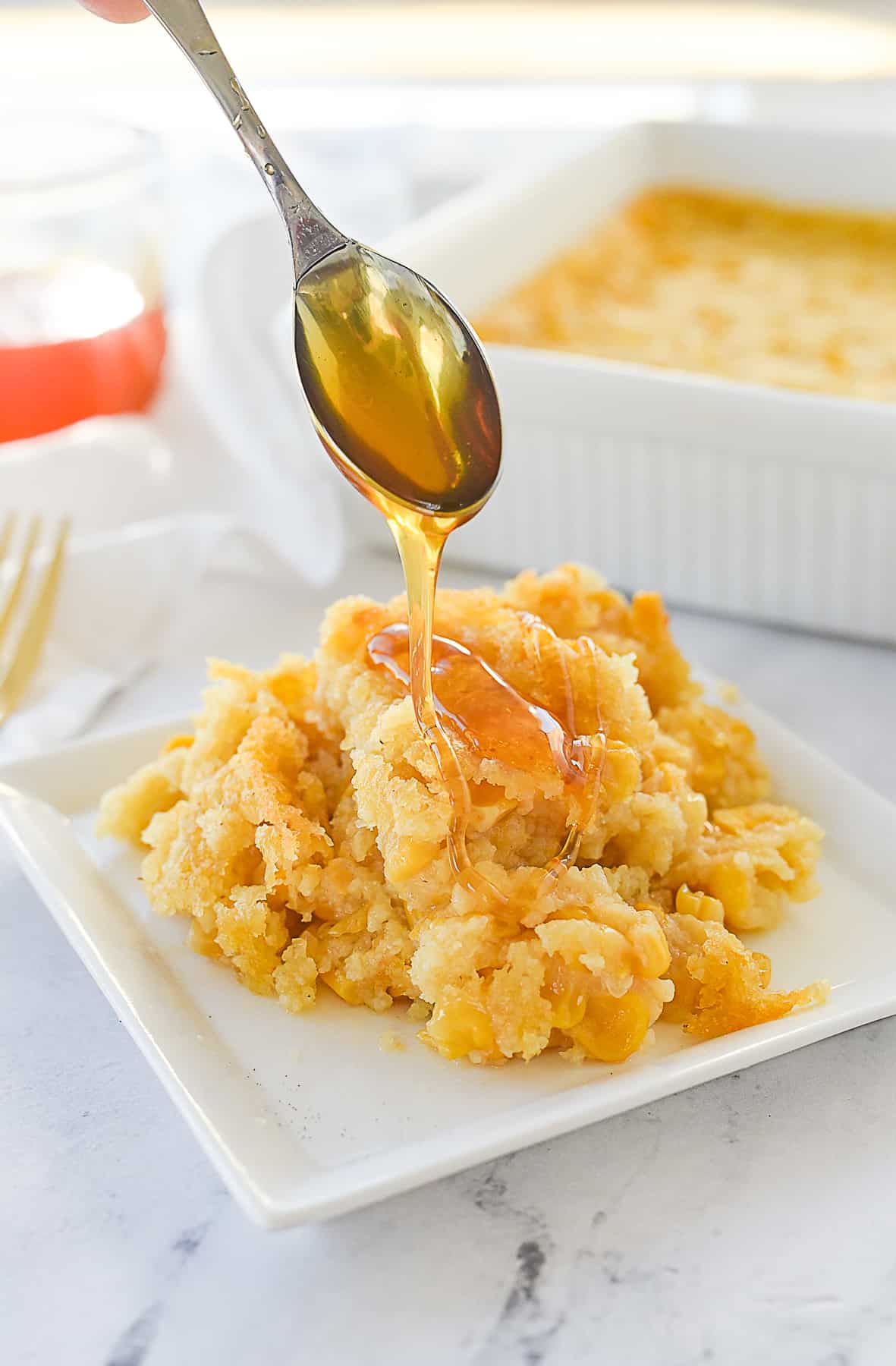 pouring honey over corn casserole