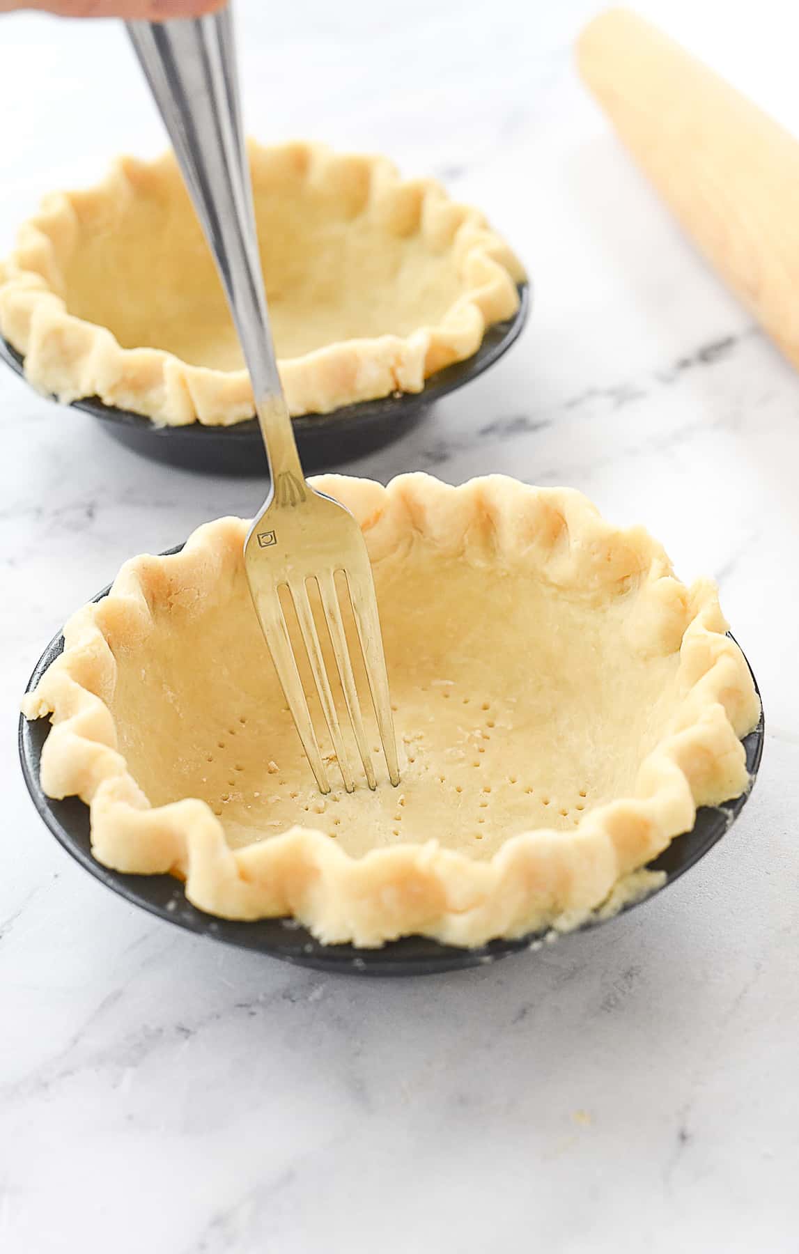 pricking bottom of pie crust.