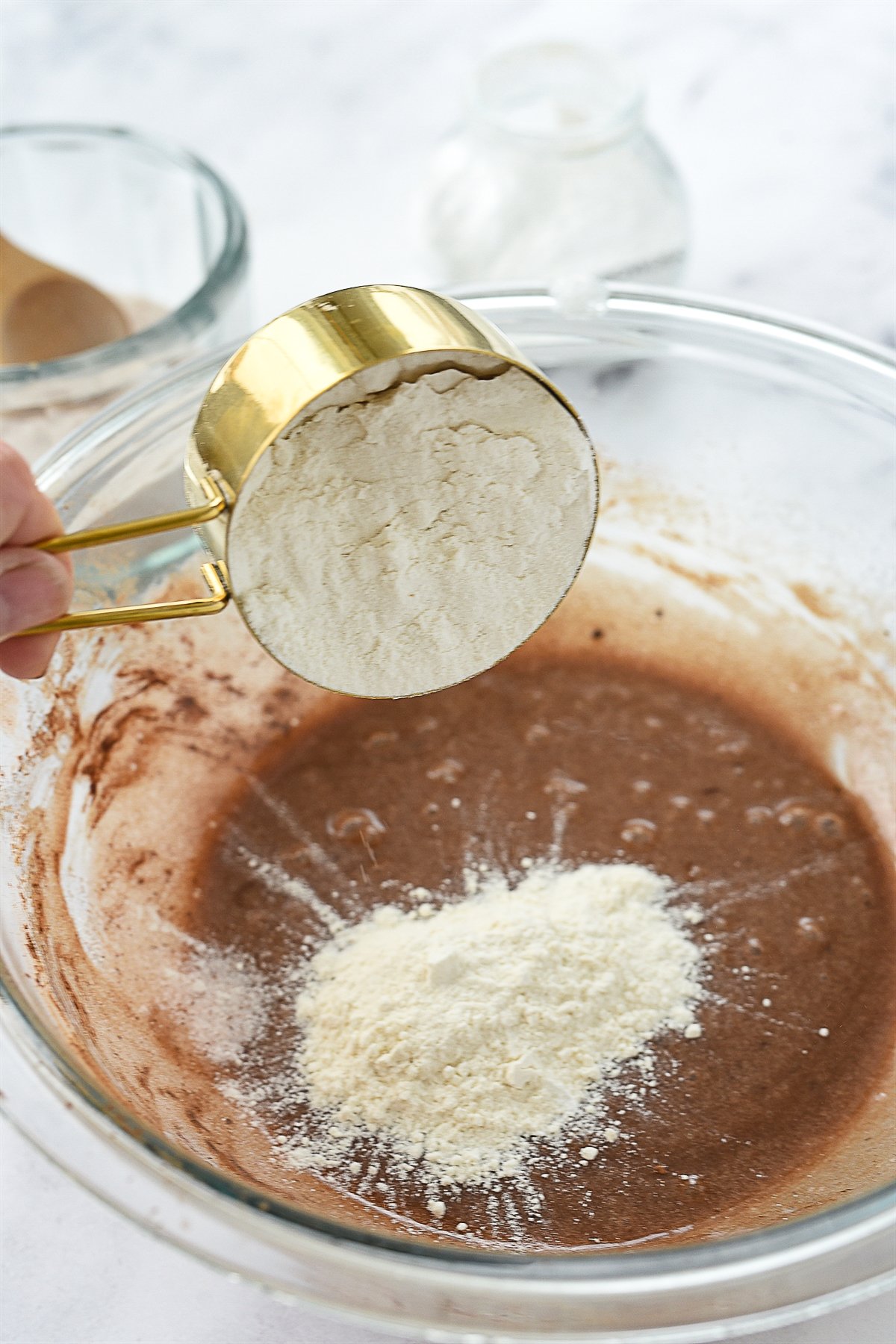 adding flour into bowl