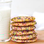 stack of sugar cookies with sprinkles and a glass of milk