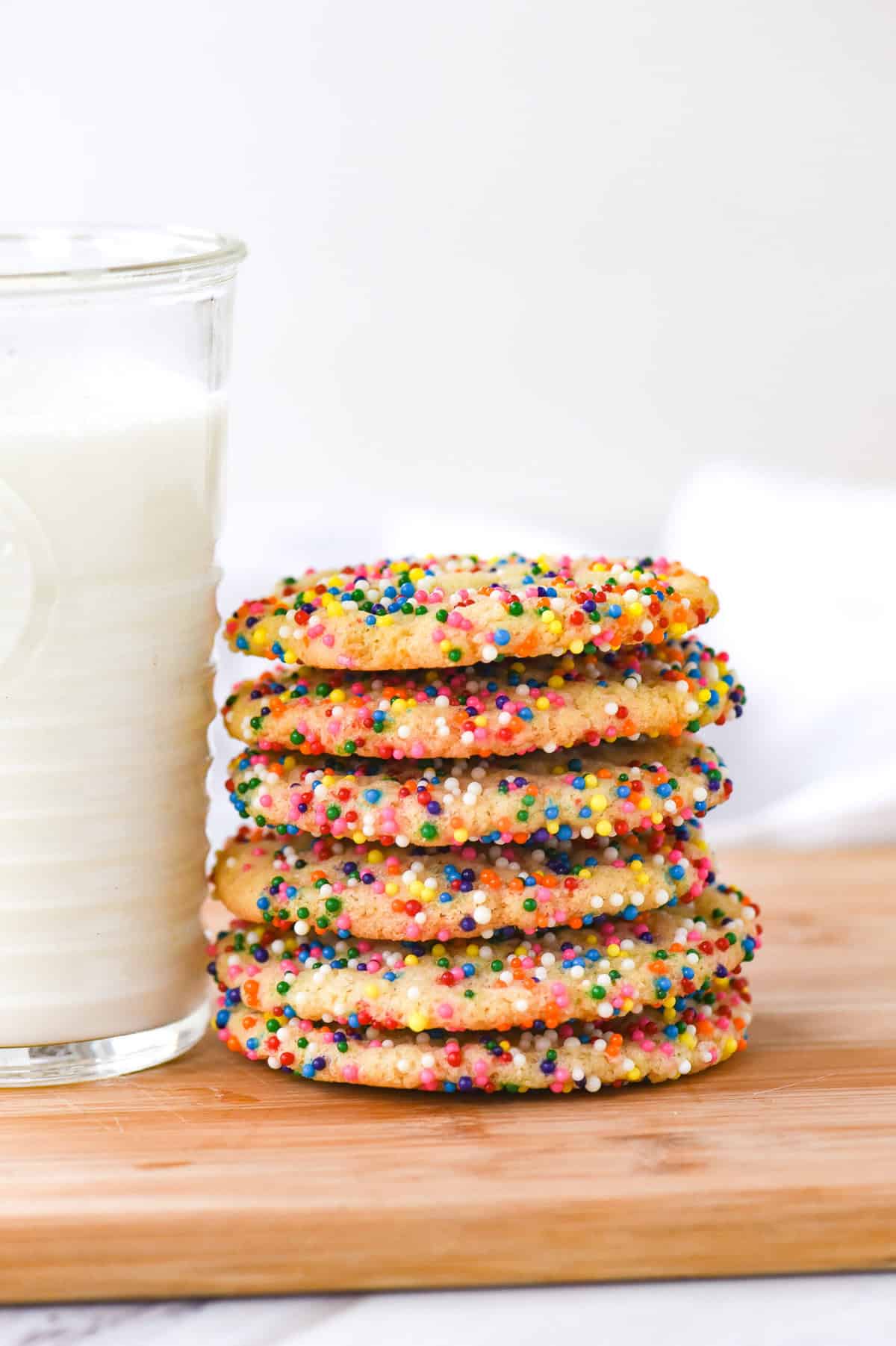 drop sugar cookie stack of sugar cookies with sprinkles and a glass of milk