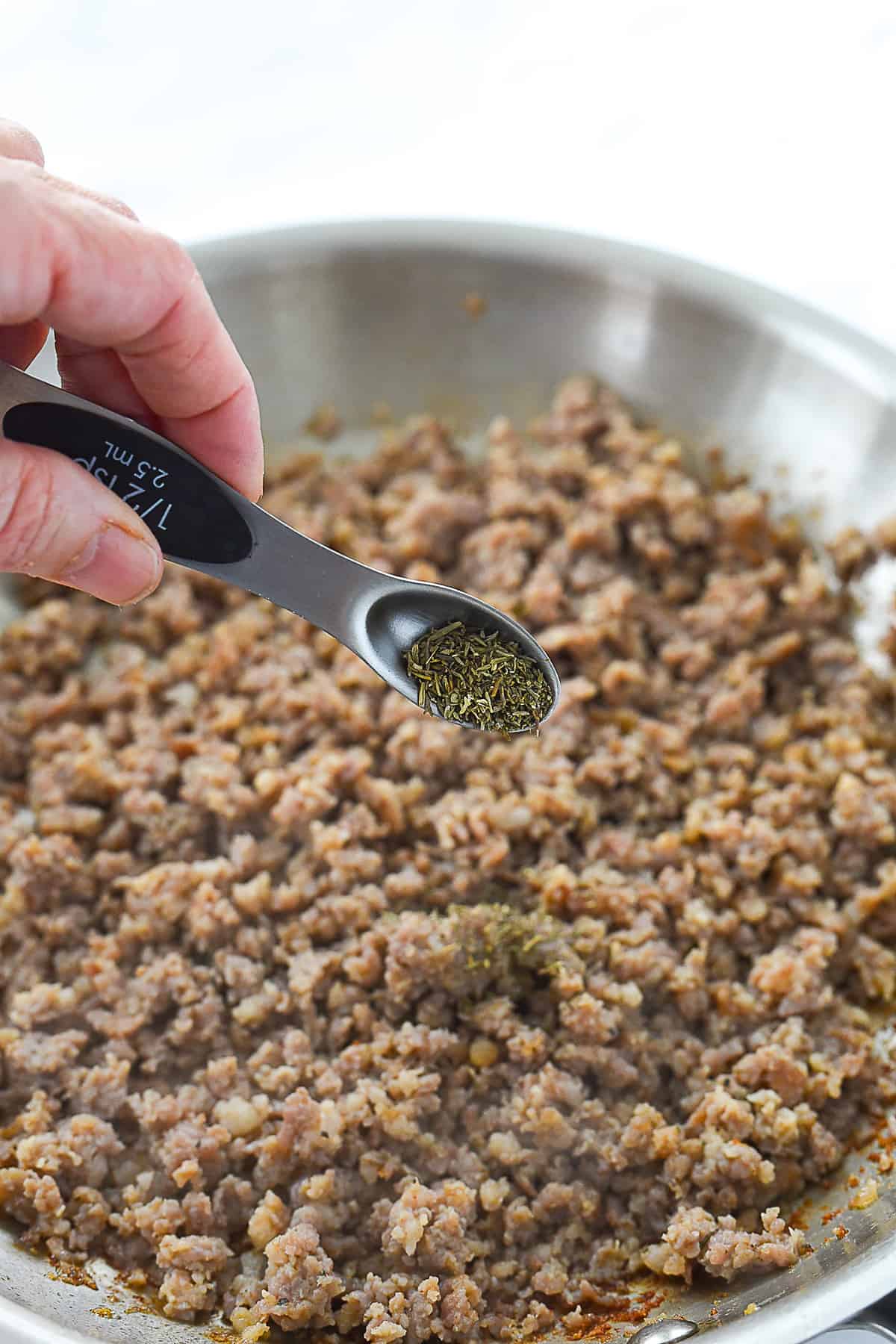 adding herbs to sausage