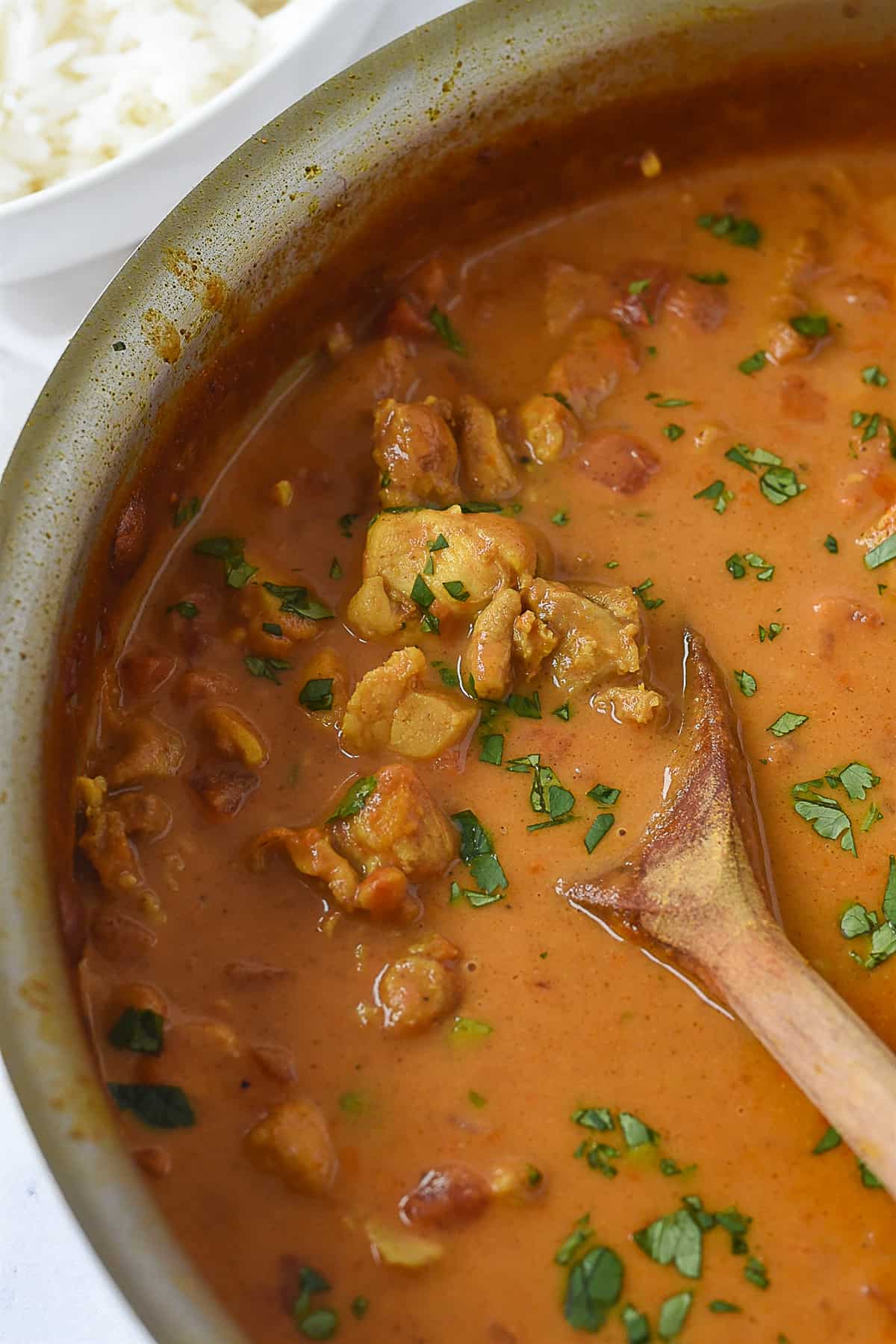 closeup of coconut curry chicken in pan.