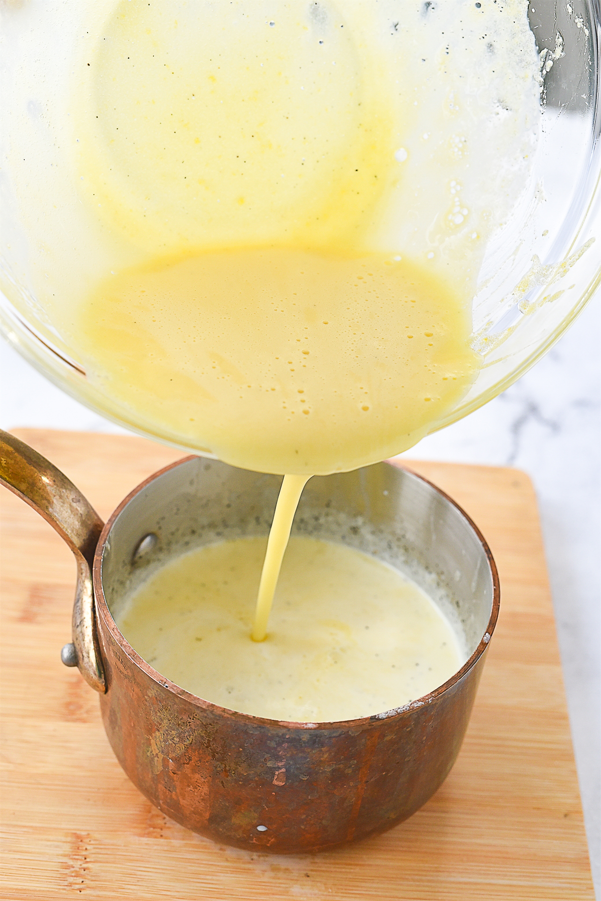 pouring egg mixture into milk