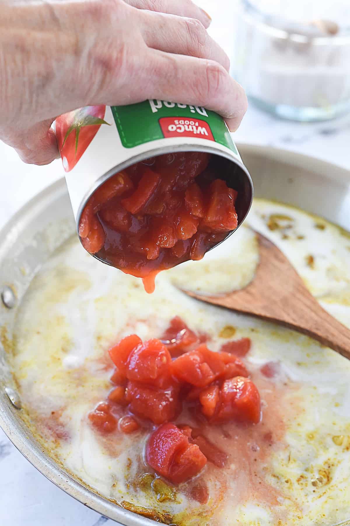 adding tomatoes to chicken korma