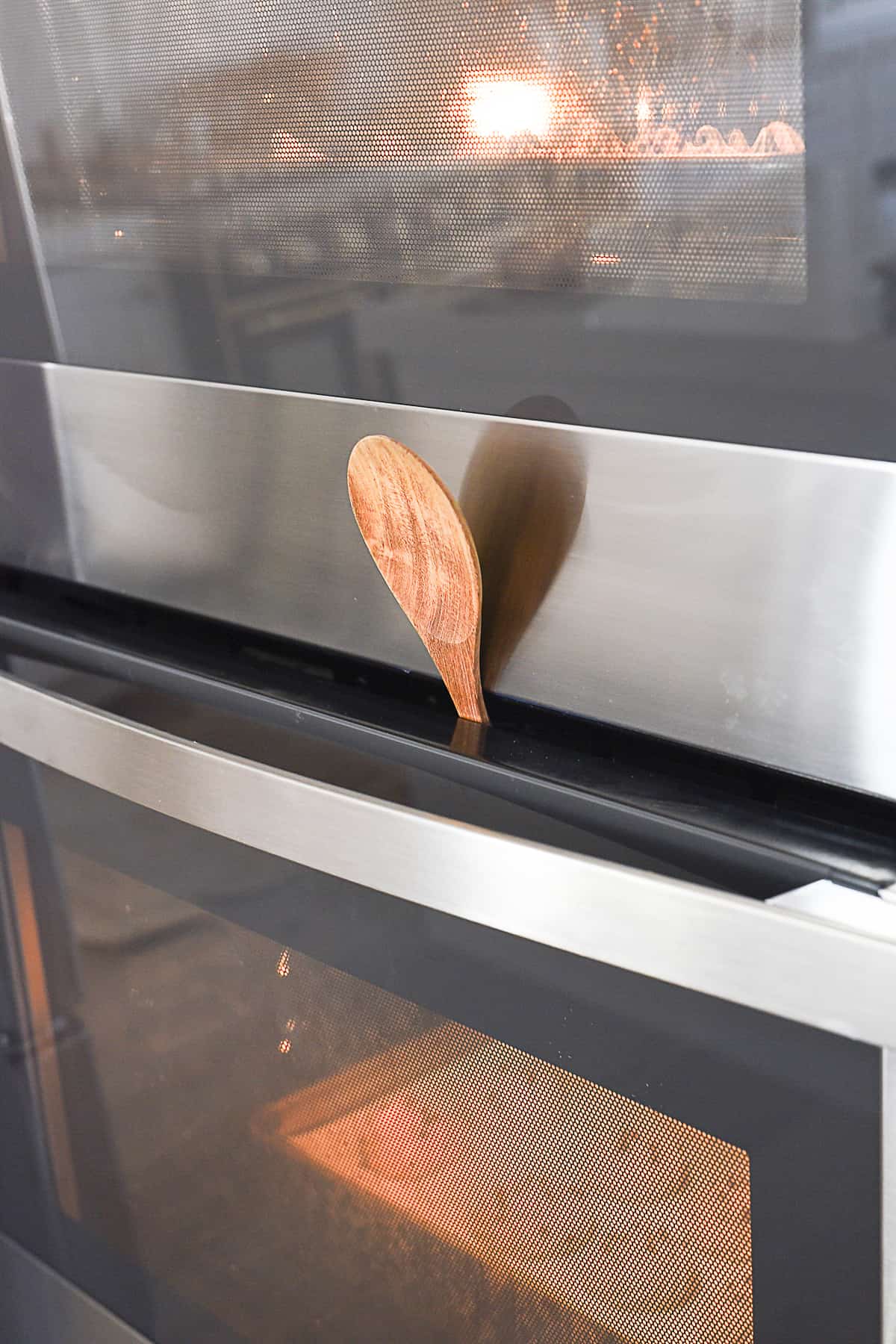 propping oven door open with wooden spoon