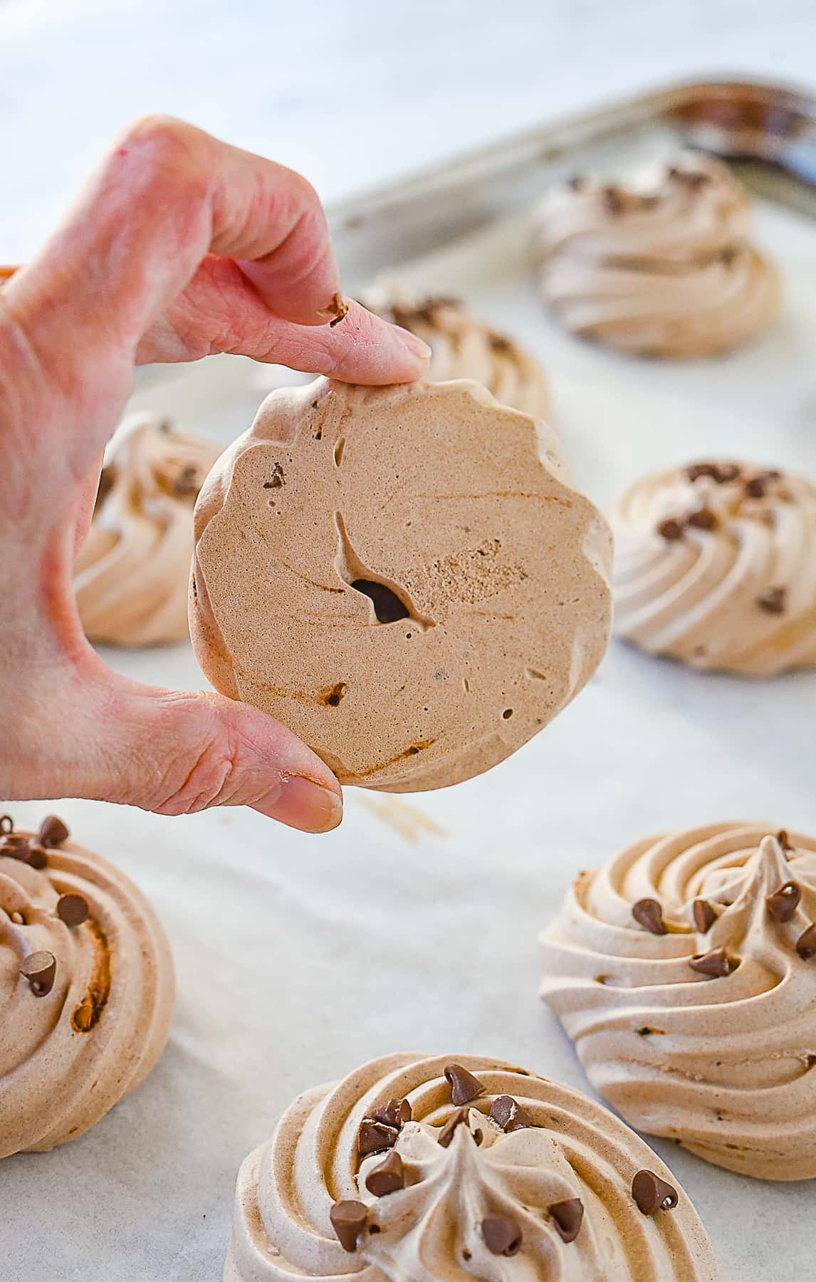 hand holding a chocolate meringue cookie