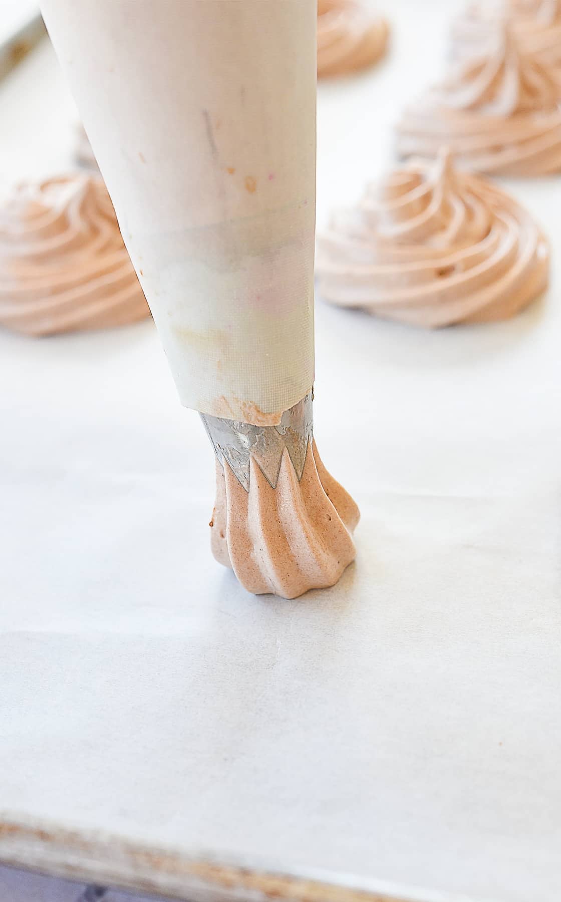 piping meringue on baking sheet