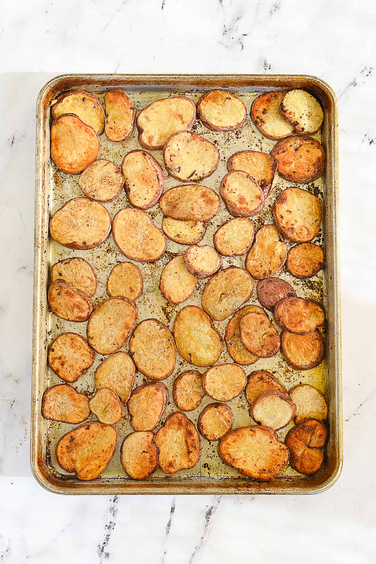 cooked sliced potatoes on a baking sheet