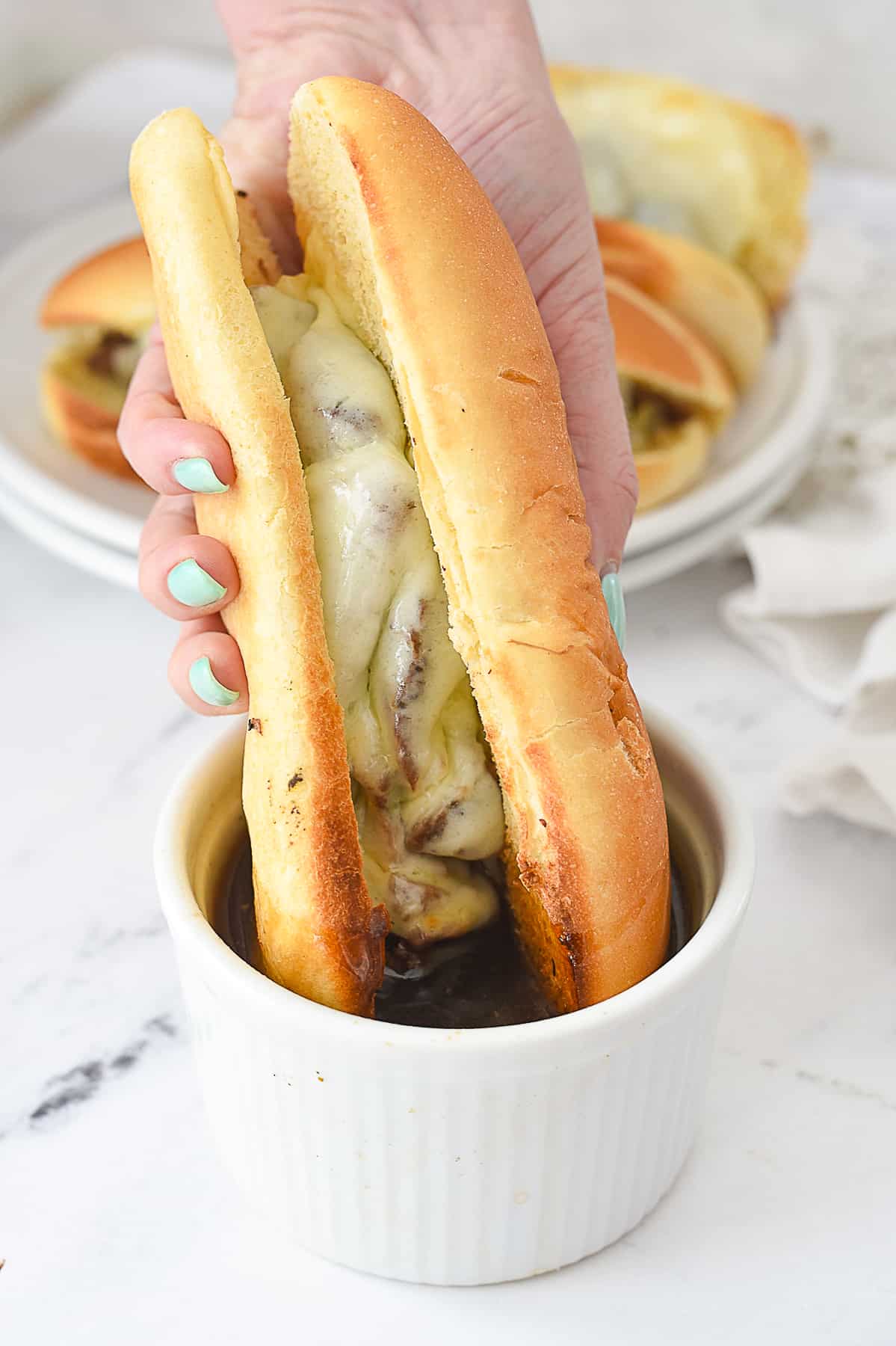 hand holding a french dip sandwich