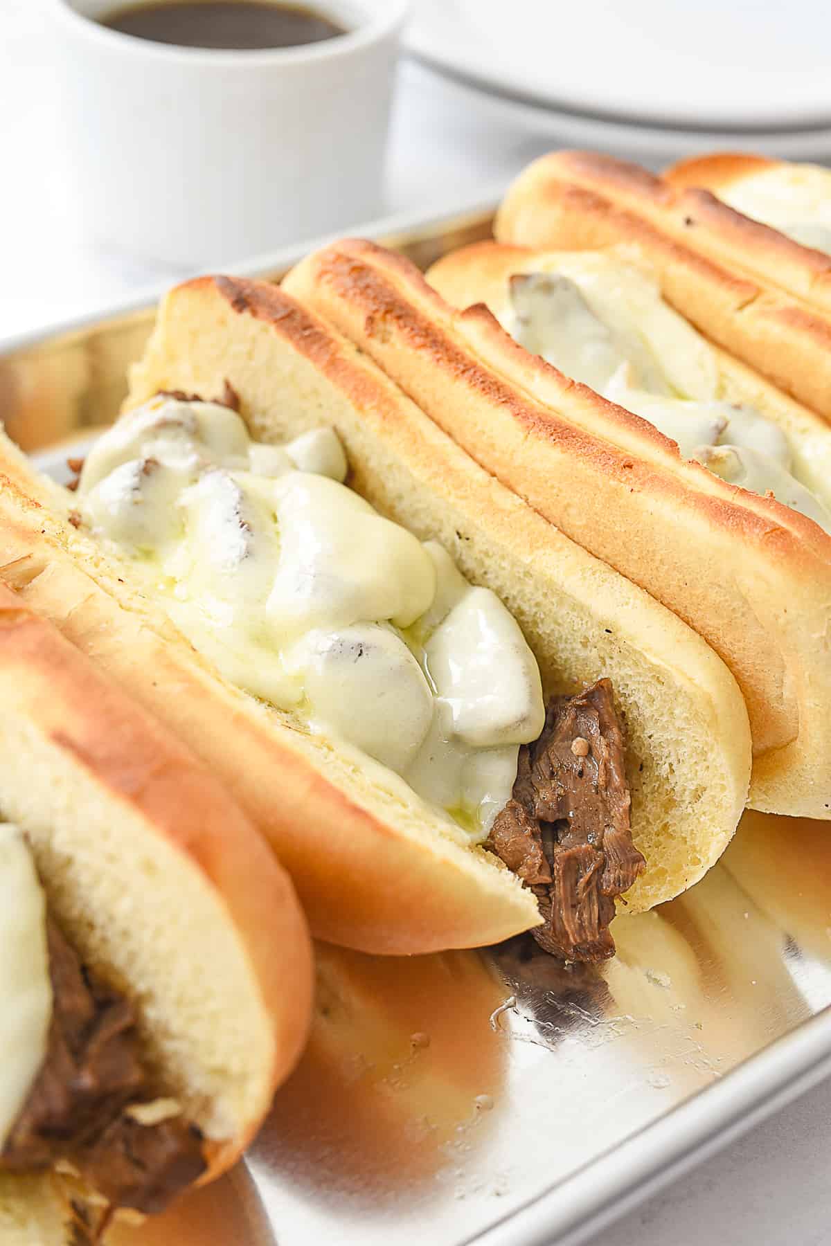 french dip sandwiches on a baking sheet