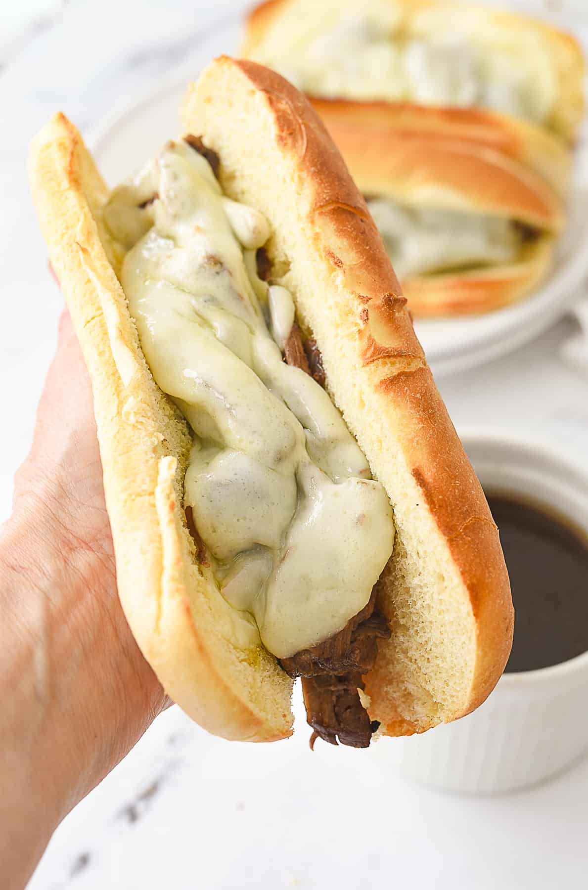 hand holding a french dip sandwich