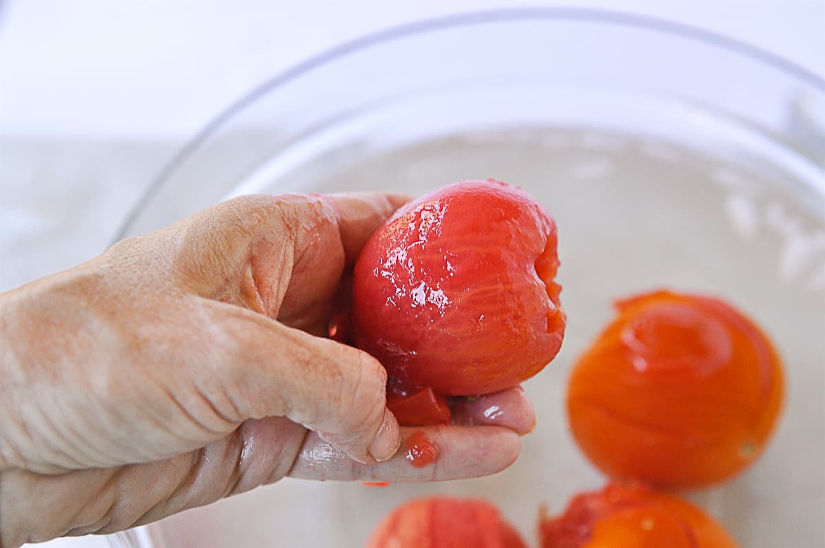 hand holding a peeled tomato