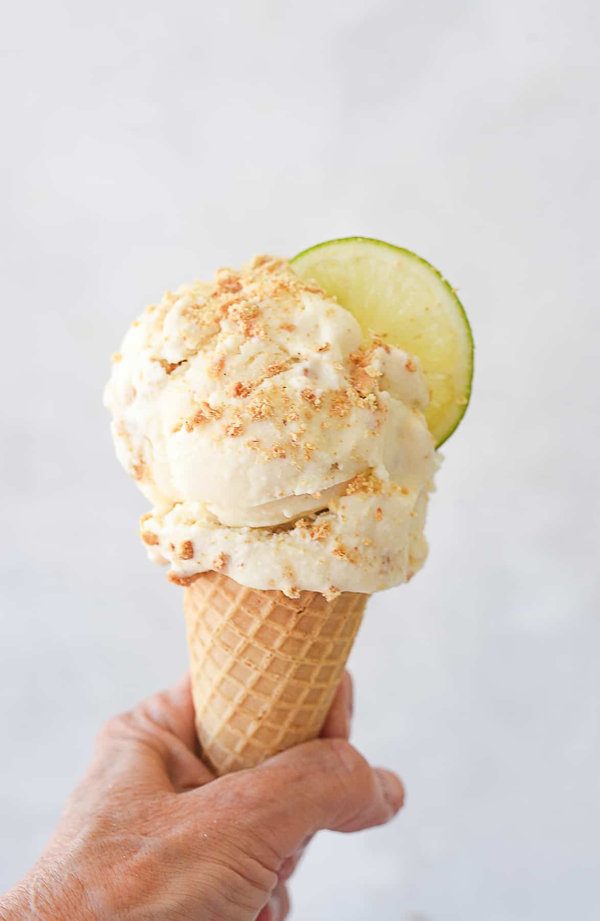 hand holding an ice cream cone of key lime pie ice cream