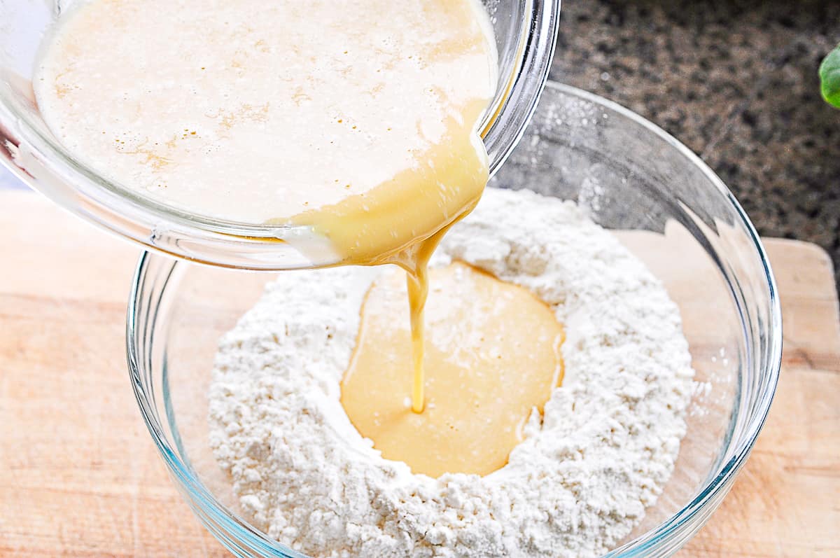 pouring egg mixture into flour for liege waffles