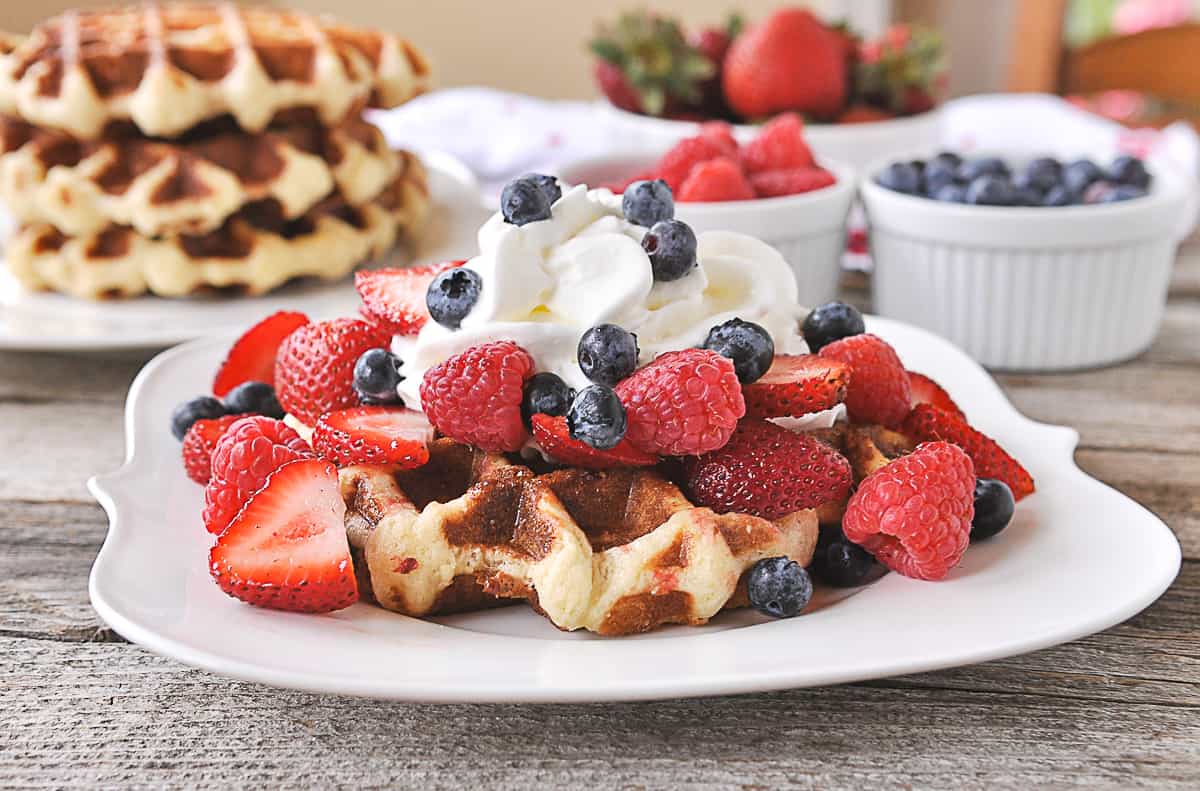 berries and whipped cream on a waffle