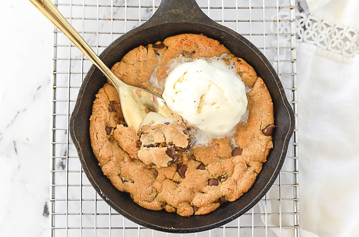 peanut butter skillet cookie with ice cream melting on it.