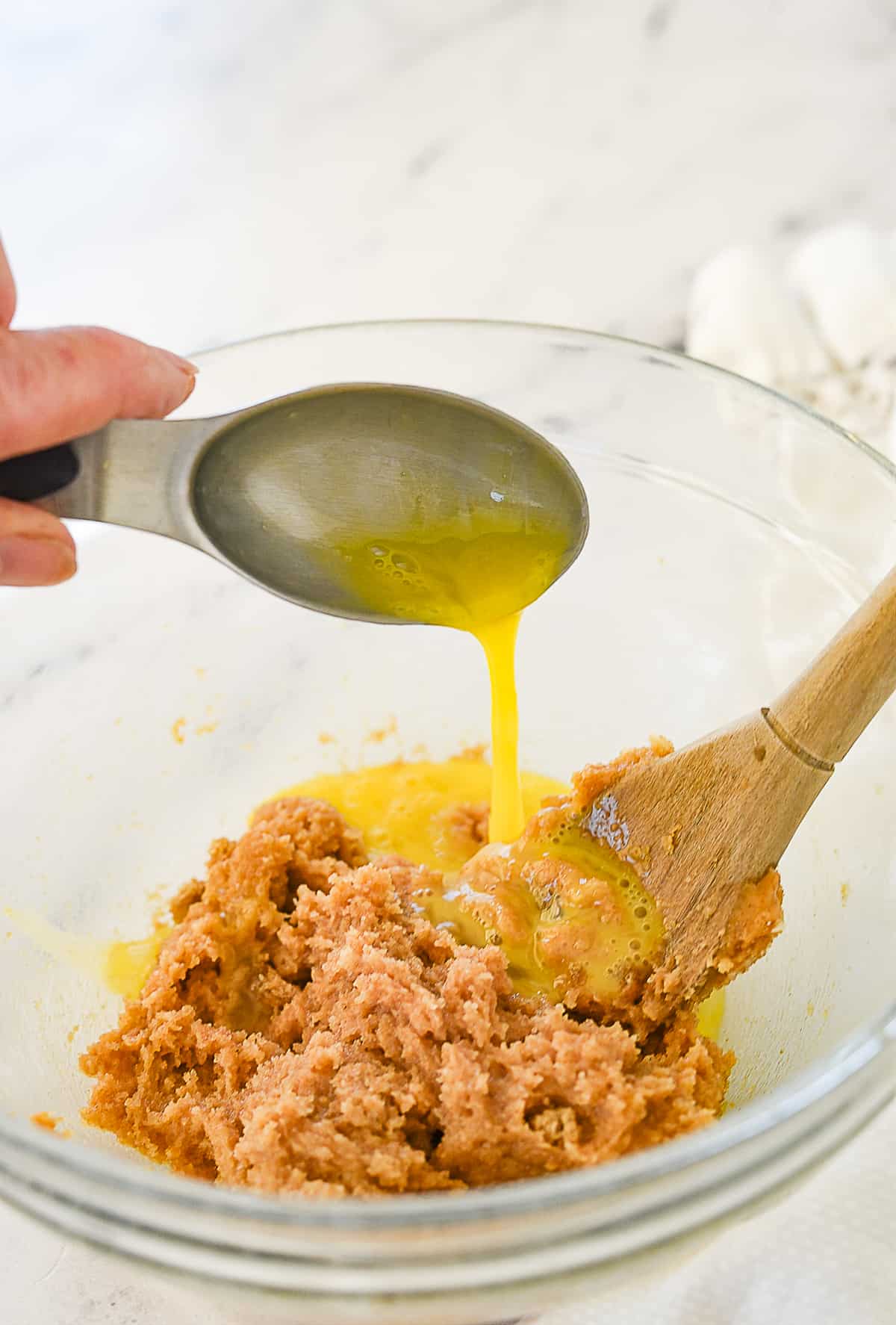 pouring egg into cookie dough