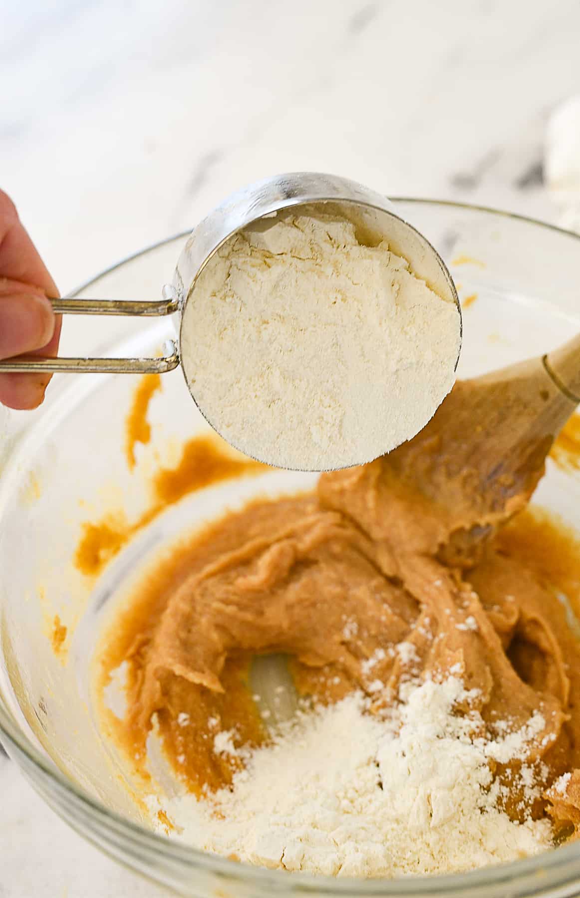 adding flour to cookie dough