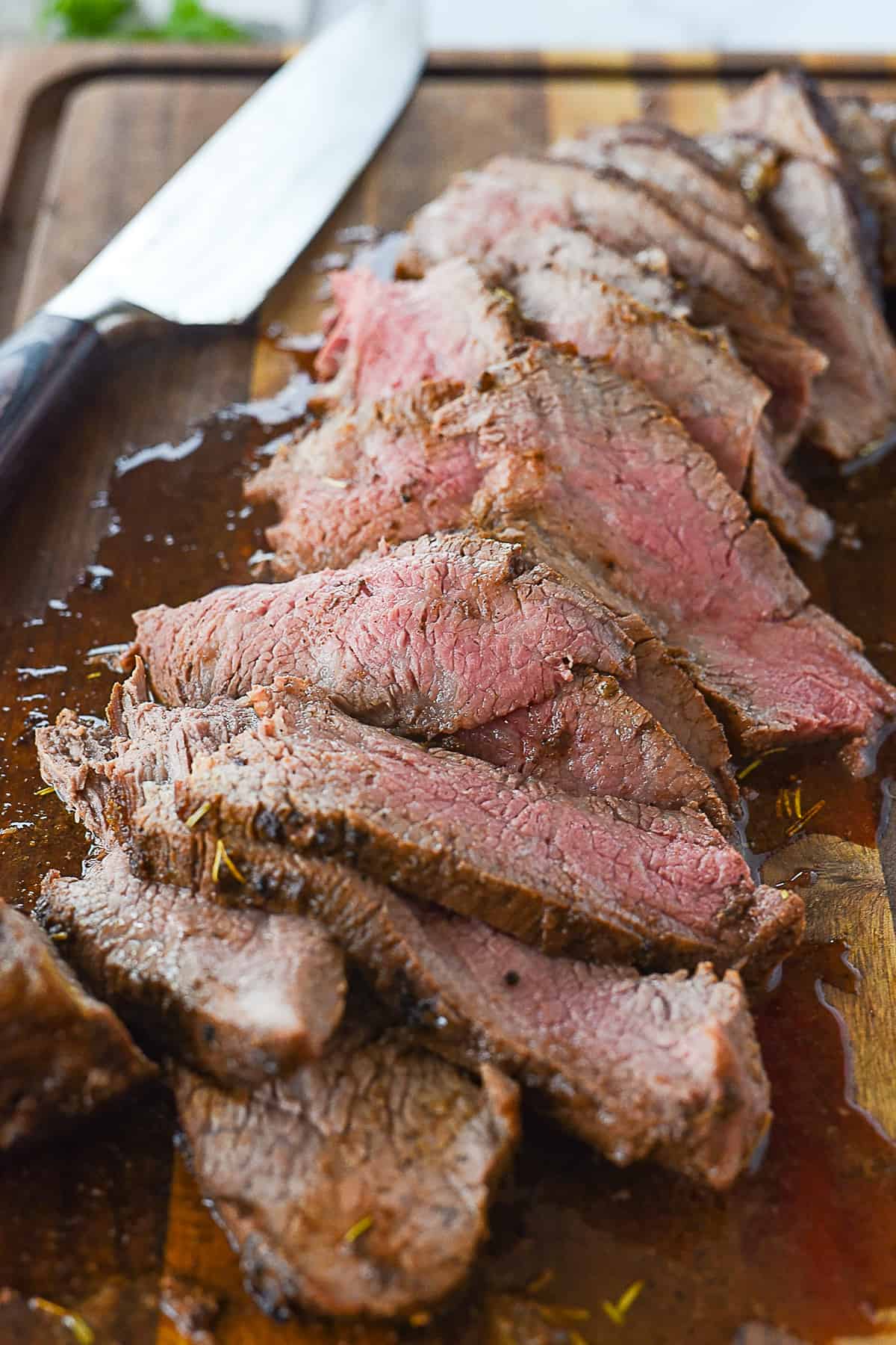 sliced tri tip on cutting board with knife
