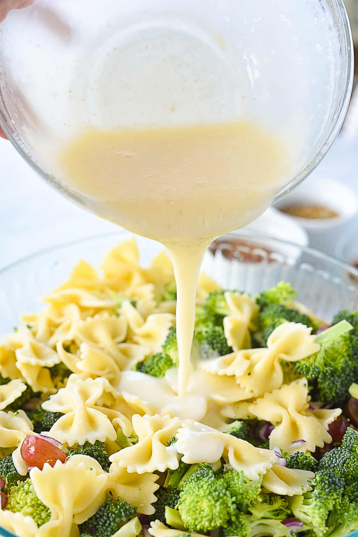 pouring dressing into broccoli salad