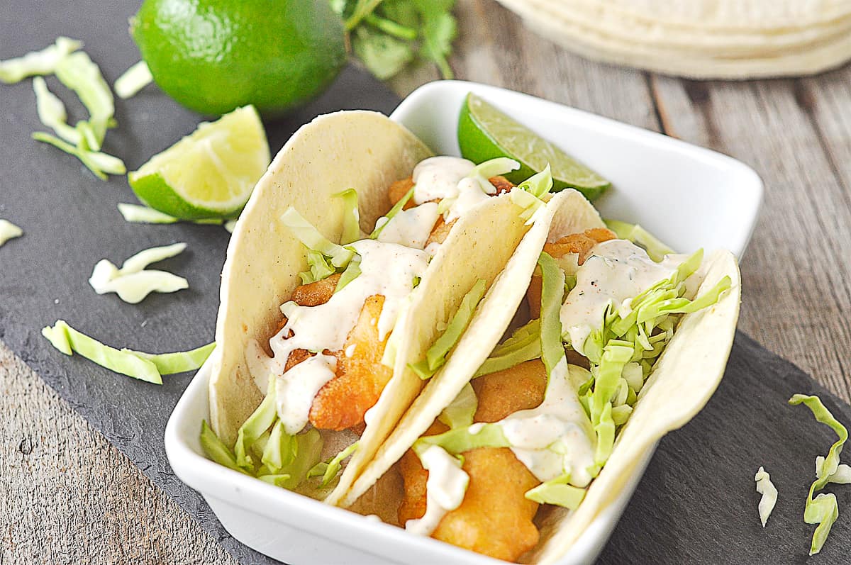 two fish tacos on a white plate