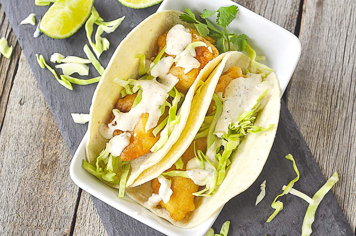 overhead of two fish tacos in a dish
