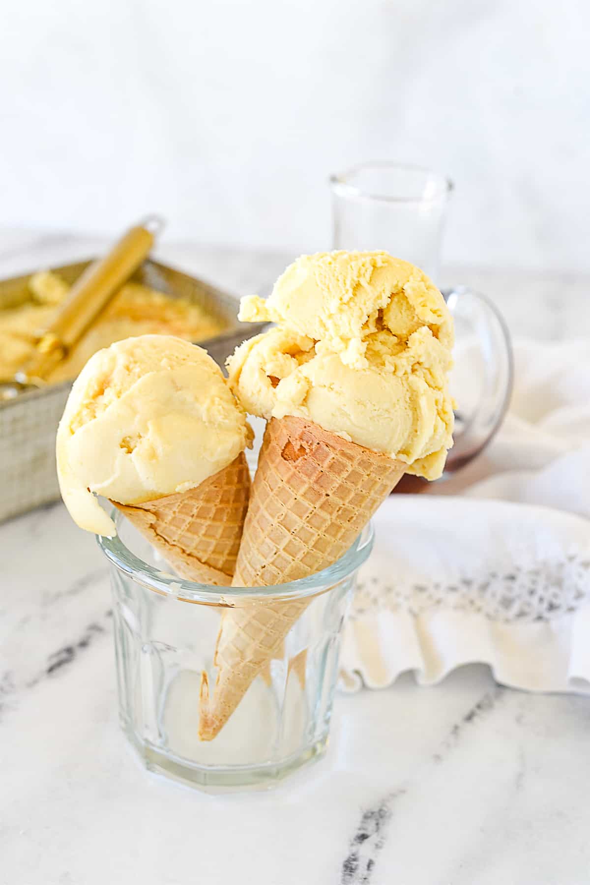 two ice cream cones in a glass with maple ice cream