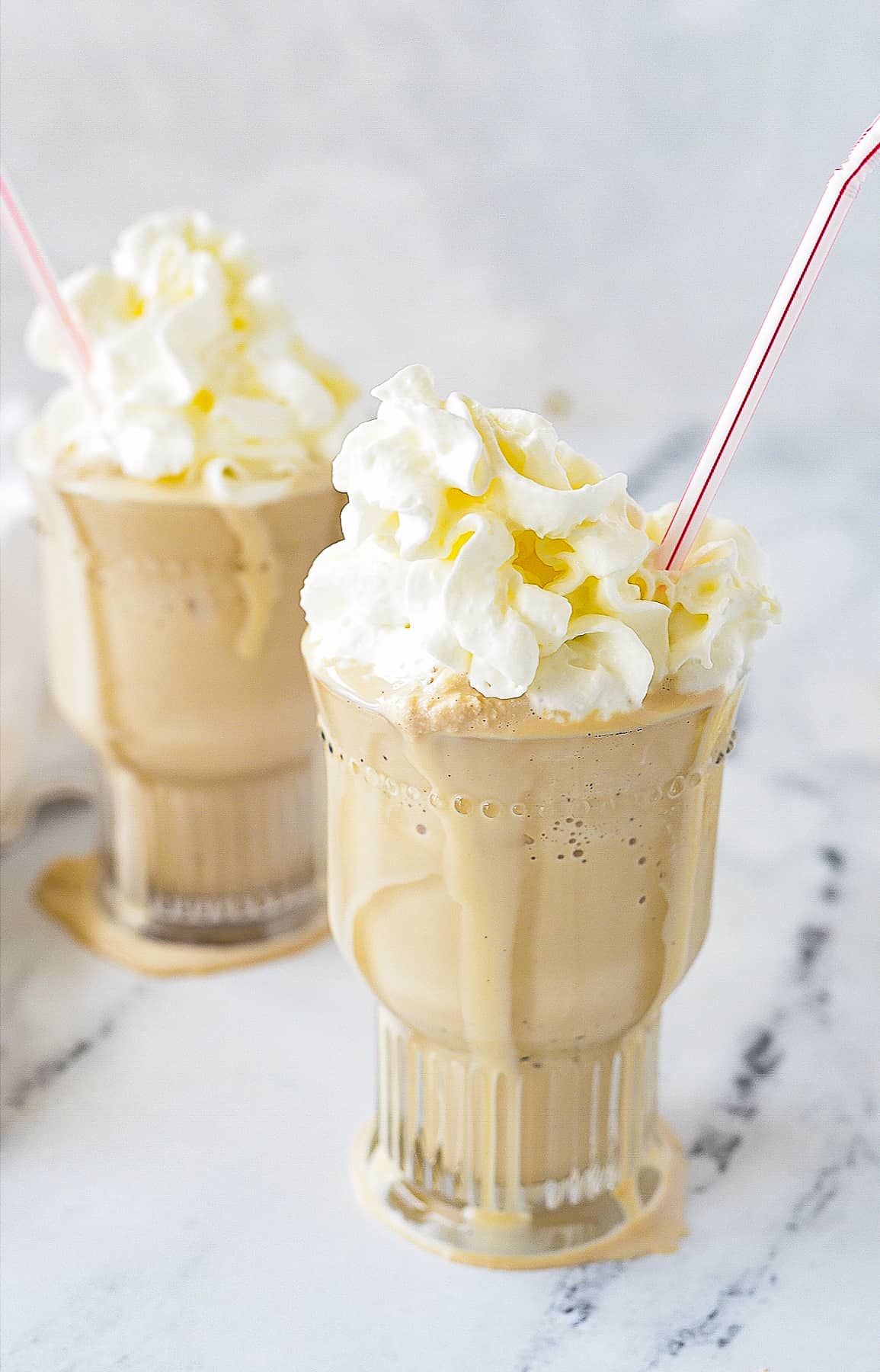 TWO ROOT BEER MILKSHAKES WITH STRAWS AND WHIPPED CREAM