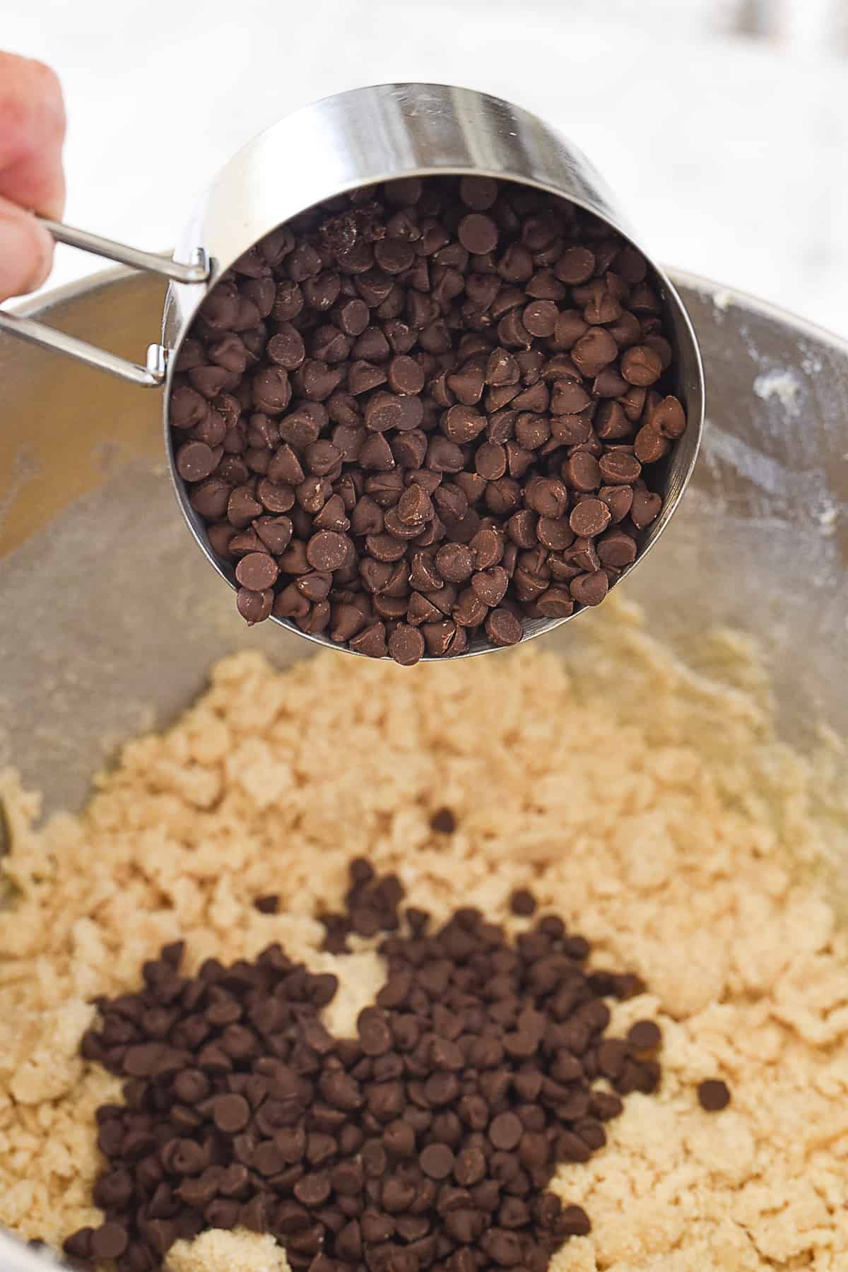 adding in mini chocolate chips to cookie dough